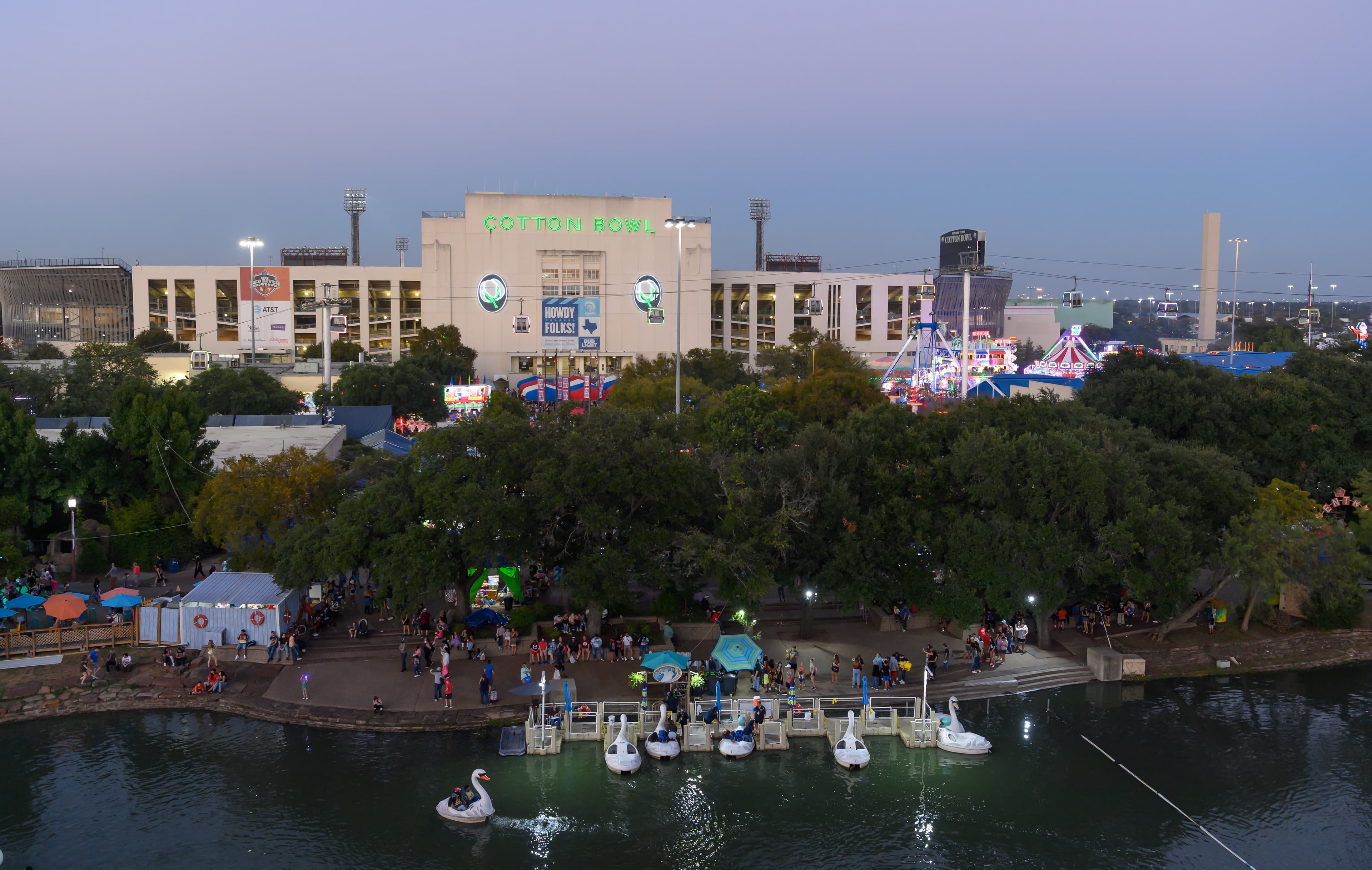 File photo: A pond, trees and fairground buildings are seen at dusk.